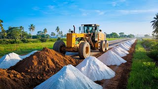 A large motor grader in action pushing and leveling a dirt surface on a road construction site [upl. by Adolfo]