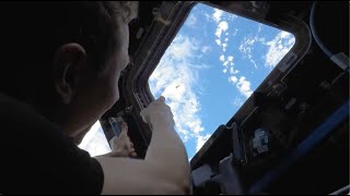 Jettisoned equipment seen floating away from space station in cupola view [upl. by Jacobine]