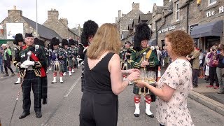 Massed Pipes amp Drums parade stops to enjoy a wee dram before 177th Tomintoul Highland Games [upl. by Yllitnahc746]