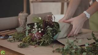 Florist wrapping flower bouquet in kraft paper [upl. by Asiruam969]