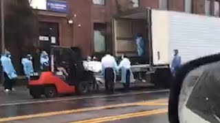 This is for real Shocking video shows body bags being forklifted into lorry in New York [upl. by Eniamej]